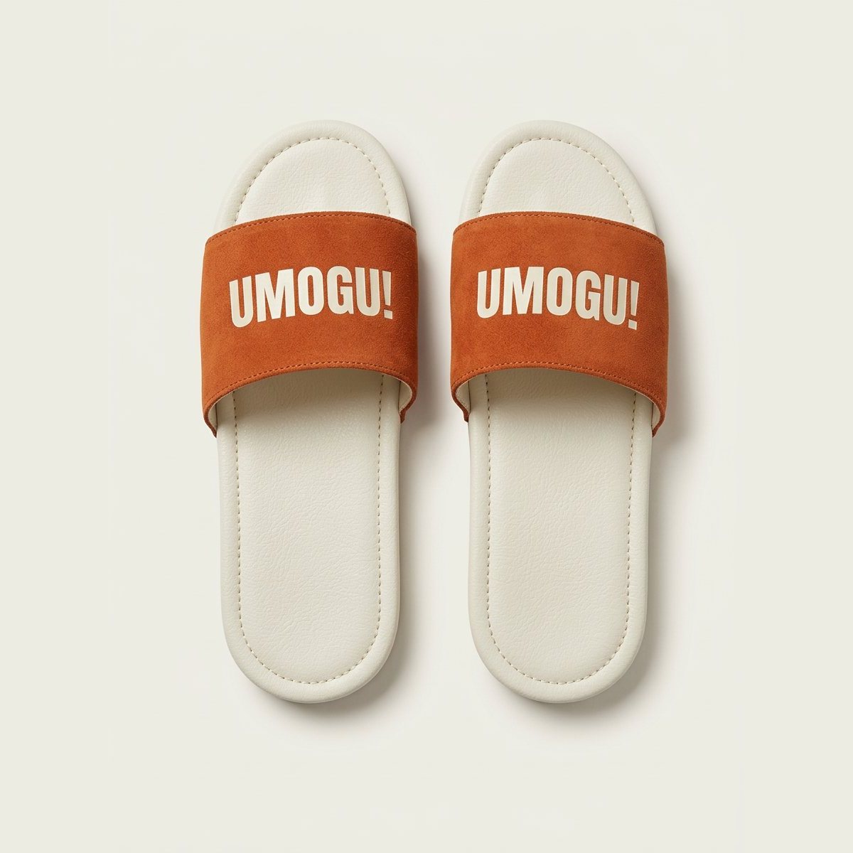 Ivory sliders with burnt orange straps printed UMOGU!.