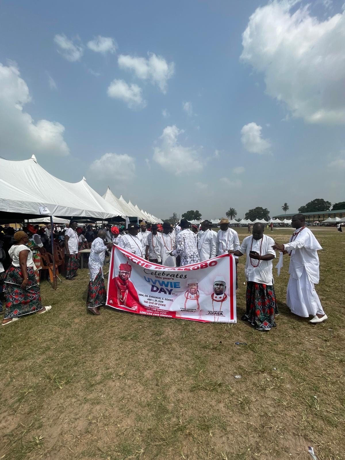 Members of an Etche delegation in white holding their banner on the festival ground.