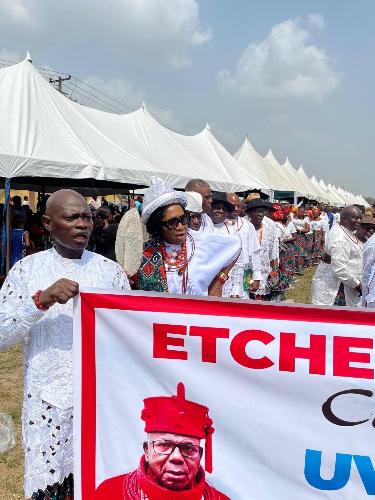 A delegation processing in white lace with red coral bead collars.